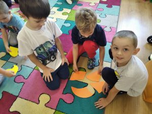 Bystrzaki - Trzech chłopców składa  z części dużą, papierową kropkę w jedną całość.