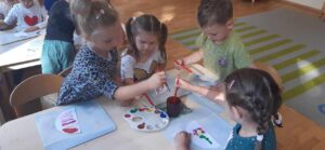 MALI ODKRYWCY - dzieci malują farbami kropki na kartce papieru
