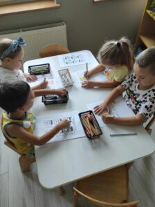 BYSTRZAKI - Grupa dzieci wykonuje zadanie przy stoliczku