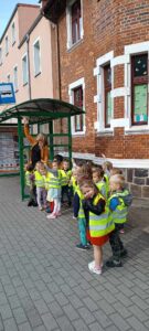 ZUCHY - Grupa dzieci stoi na przystanku autobusowym